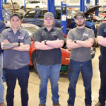 Seven males students in a row in auto shop