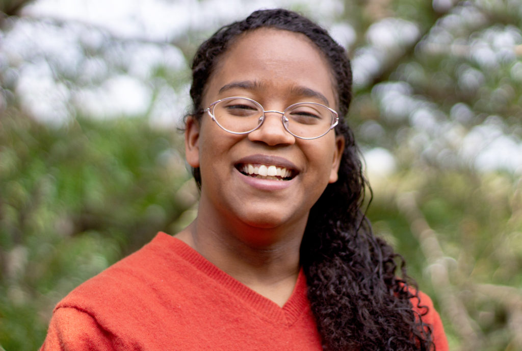 Female student, smiling, looking at camera.