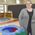 Female student standing in children's play area.