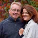 Couple looking forward in front of colorful trees