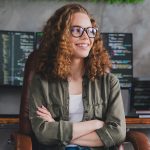 Woman sitting in front of computers.