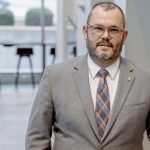 Dr. Jeremy Pickard standing, wearing a suit.