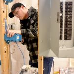 Student working on electrical equipment.