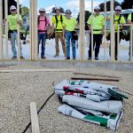 Students standing behind the duplex wall frame.