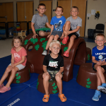 Six young children sitting on a new piece of equipment.