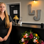 Woman standing by restuarant podium.