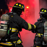 Three firefighters outside of door.