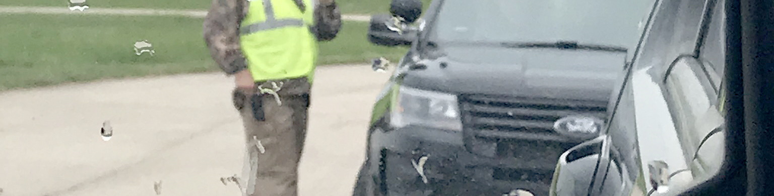 Law Enforcement Academy  student standing in rain outside vehicle